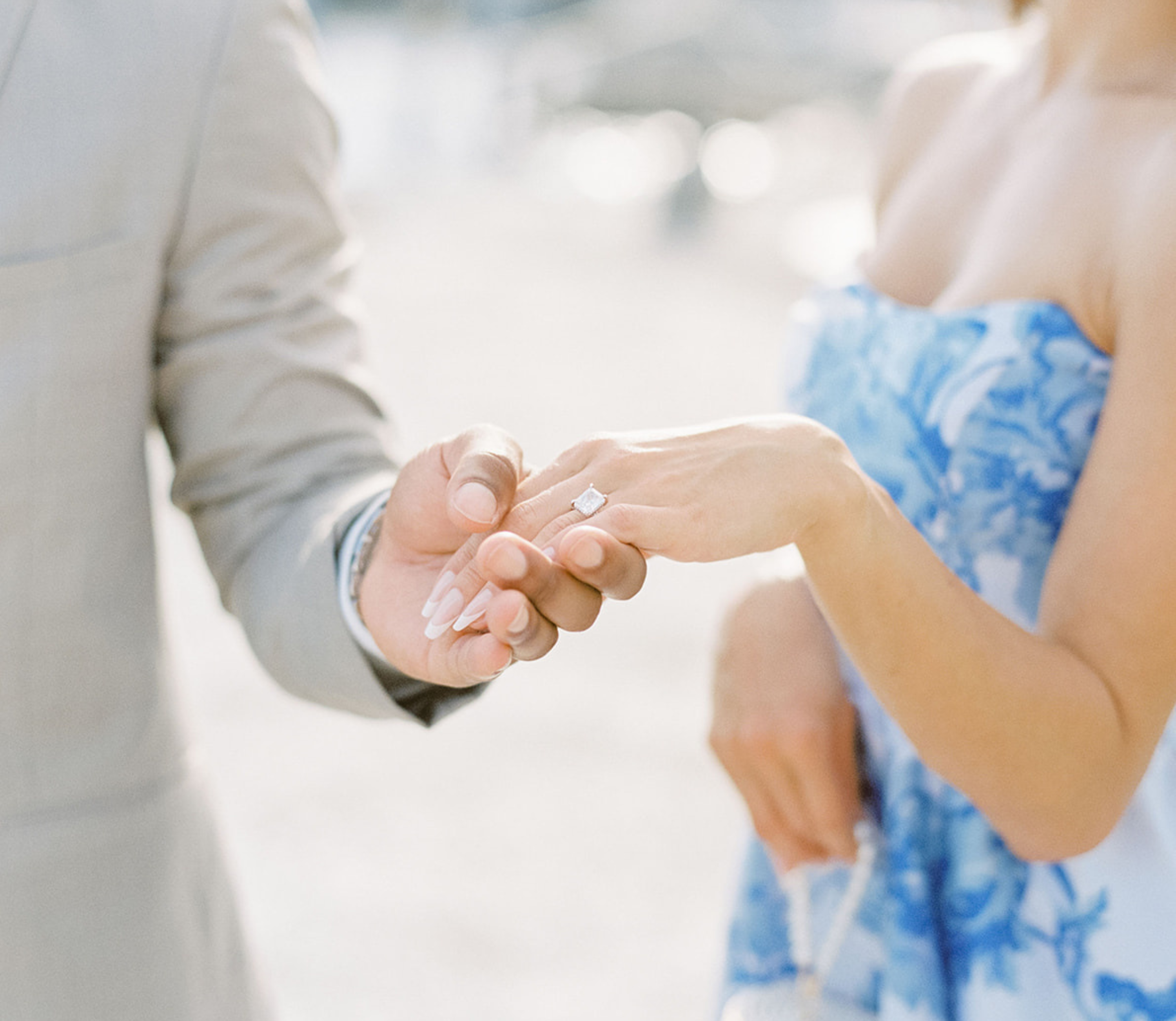 Two people holding hands with a blurred background